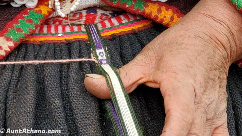 old Quechuan woman's hand weaving a simple pattern